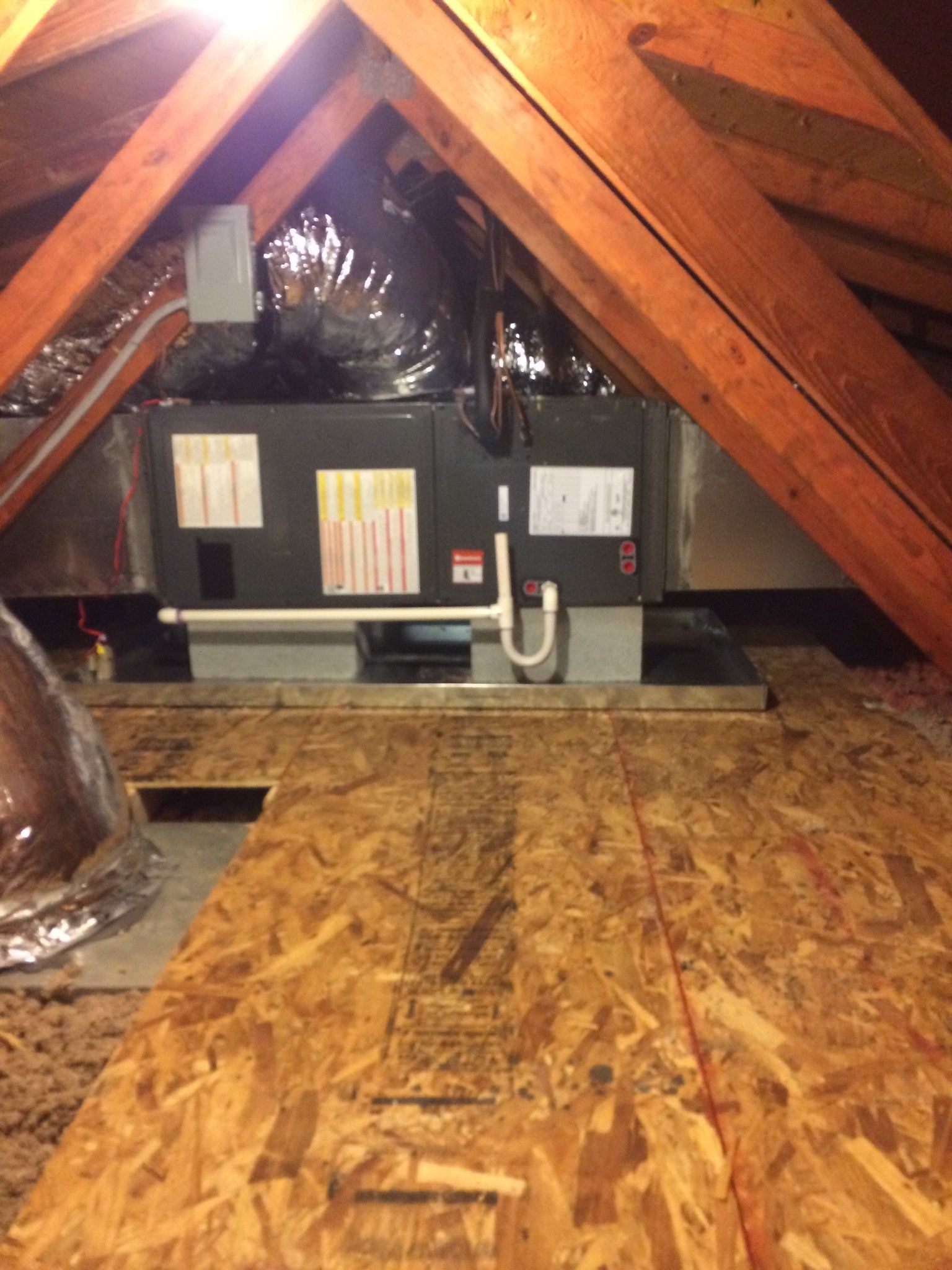 The attic of a home with a heating unit in the corner