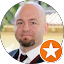 A bald man with a beard is wearing a suit and tie.