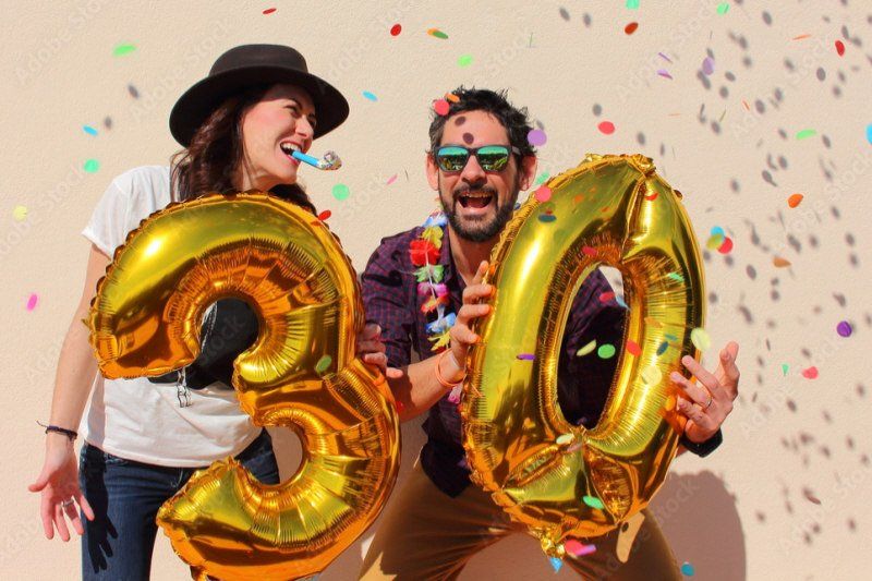 Adult Social Event 30th birthday party with couple holding gold number-shaped balloons