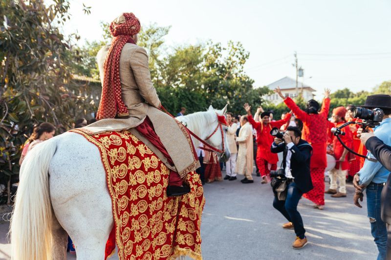 Indian groom riding a white horse