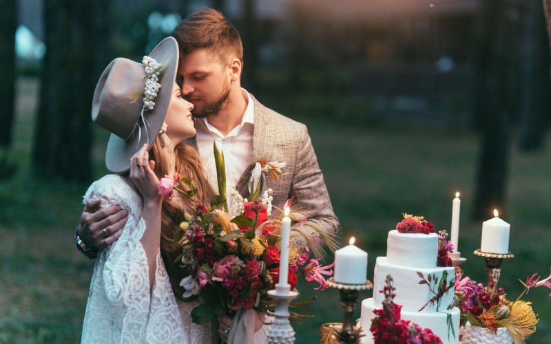 Couple at Bohemian style wedding with cake