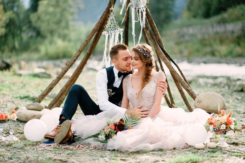 Wedding celebration Bohemian styled wedding setting teepee and couple embracing