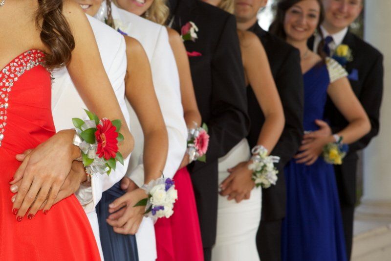 Student events prom theme showing several couples in a line with corsages shwoing