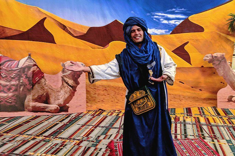 Meet and Greet entertainment image showing  tirbal greeter dressed in blue Arabian costume