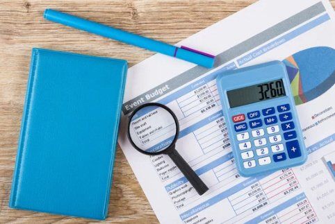 a magnifying glass is sitting on top of a piece of paper next to a calculator .