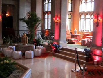 a large room with a table and ottomans in it.