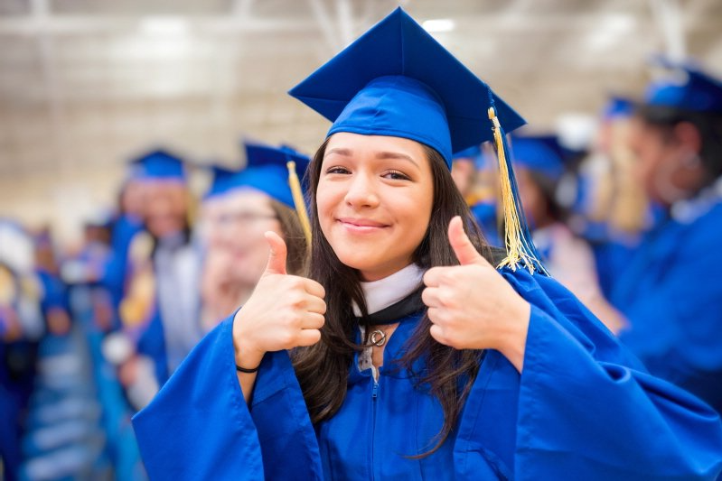 Student events graduate showing thumbs up during ceremony