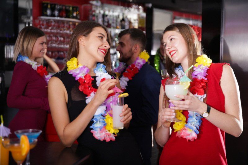 Ladies at Hawaiian Theme Party drinking Luau Drinks