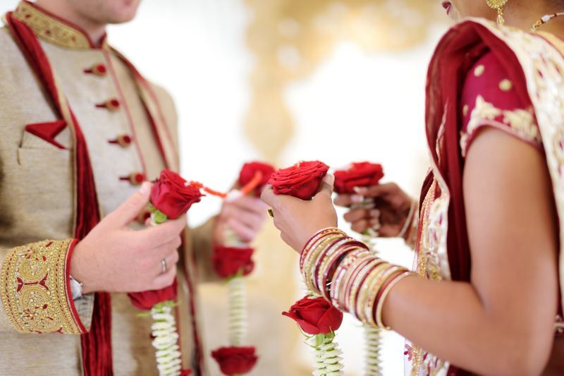 bride and groom exchanging vermala floral garlands