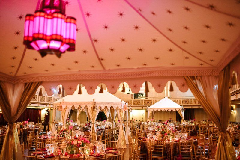 Wedding celebration in a Moroccan styled indoor setting including tents and table settings