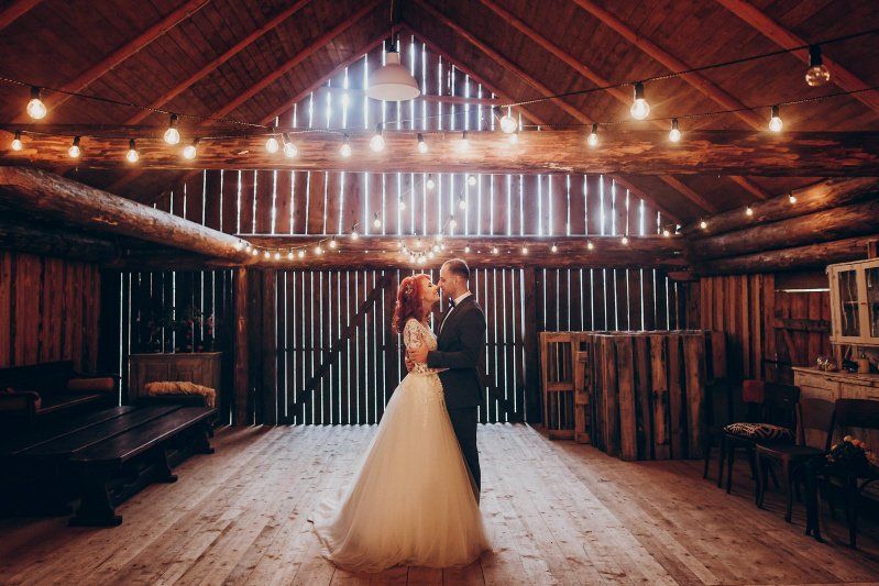 Wedding celebration rustic decoration barn with soft lighting and couple embracing