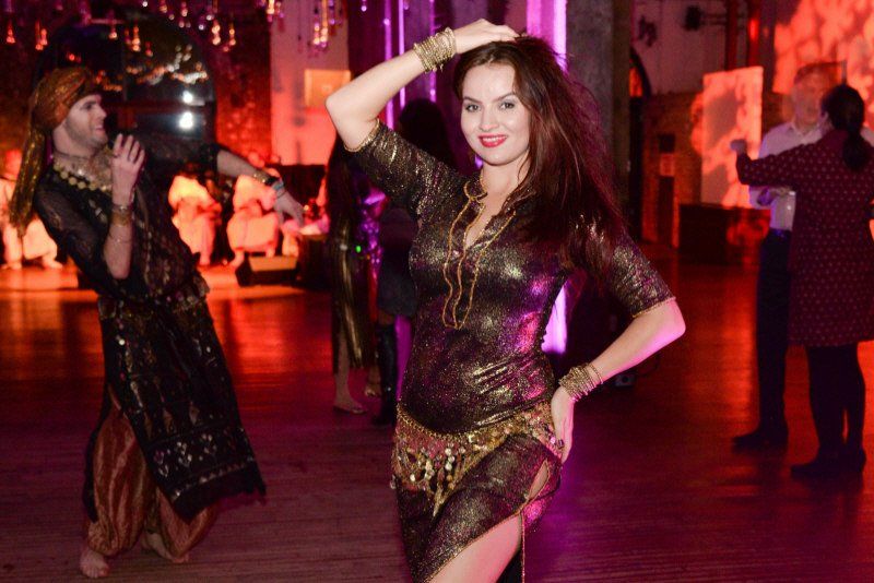 Strolling entertainment image showing belly dancer walking through the crwod
