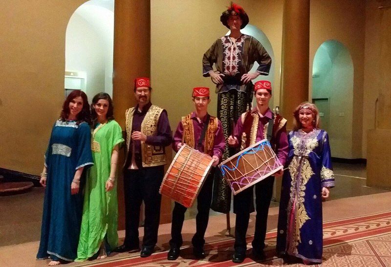 Strolling entertainment image showing mobile musicians accompanied by a stiltwalker