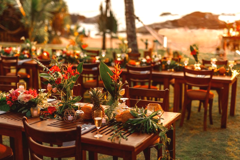 Wedding celebration tropical styled table settings with floral arrangments