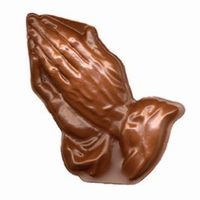 Praying hands statue, bronze color, resting on a flat surface.