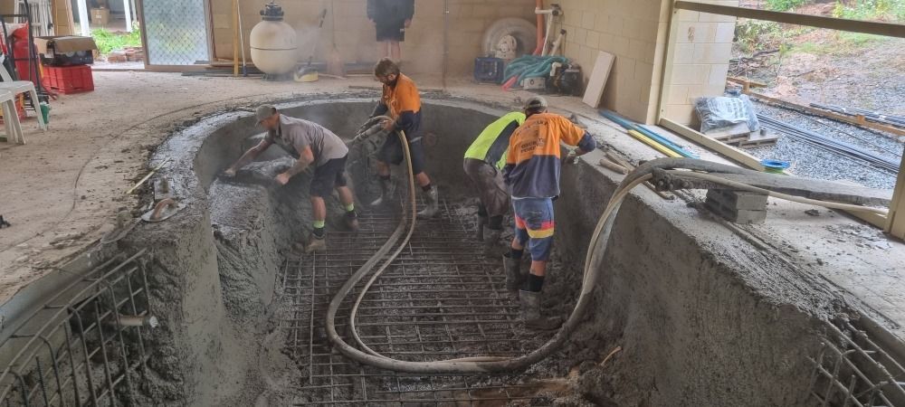 A Group Of People Are Working On A Swimming Pool — CJB Pools in Gympie, QLD