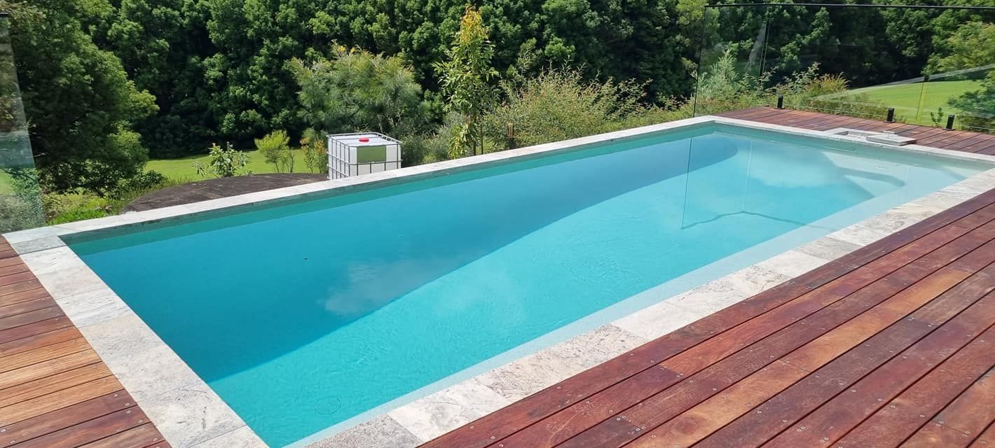 A Large Swimming Pool Is Sitting On Top Of A Wooden Deck — CJB Pools in Gympie, QLD