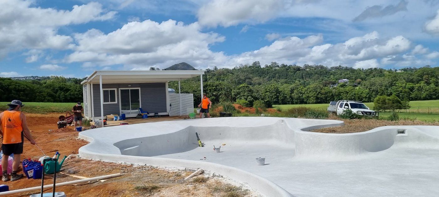 A Swimming Pool Is Being Built In Front Of A House — CJB Pools in Pie Creek, QLD