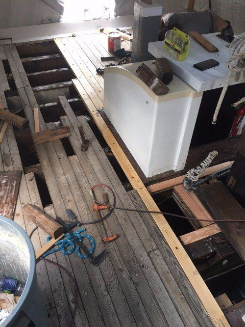 A room with a wooden floor and a white refrigerator