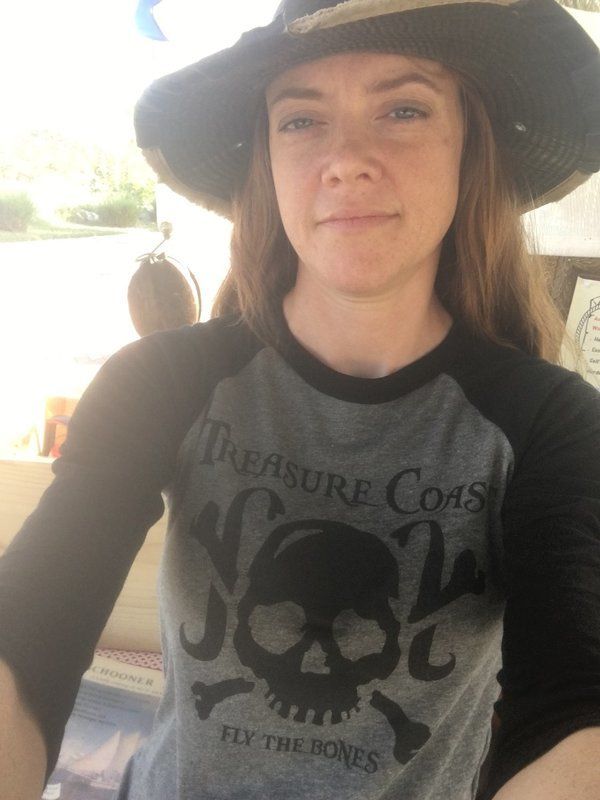 A woman wearing a hat and a shirt that says treasure coast