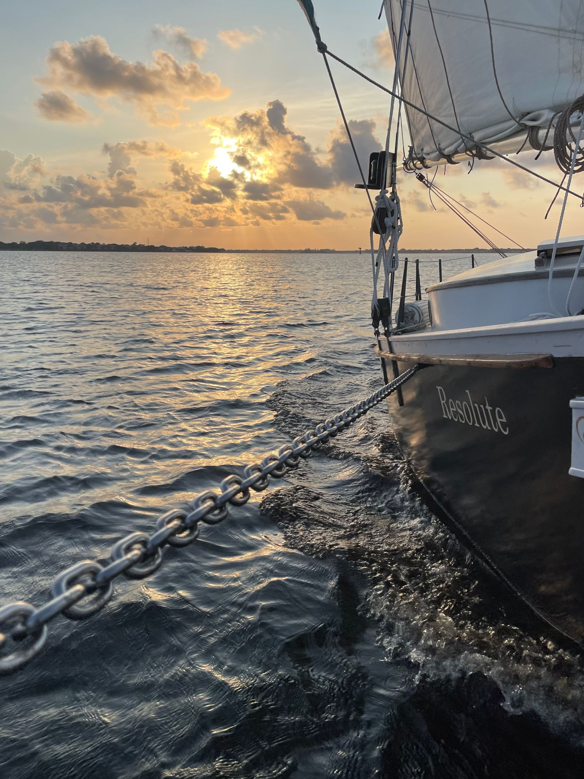 A sailboat is sailing in the water at sunset at Treasure Coast Sailing Adventures