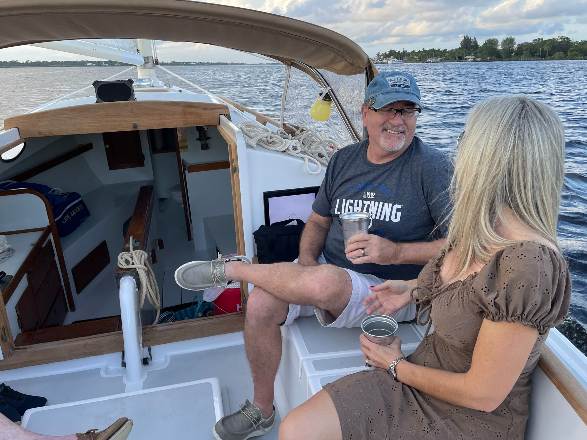 A man and a woman are sitting on a boat in the water. Romantic Anniversary Sunset cruise