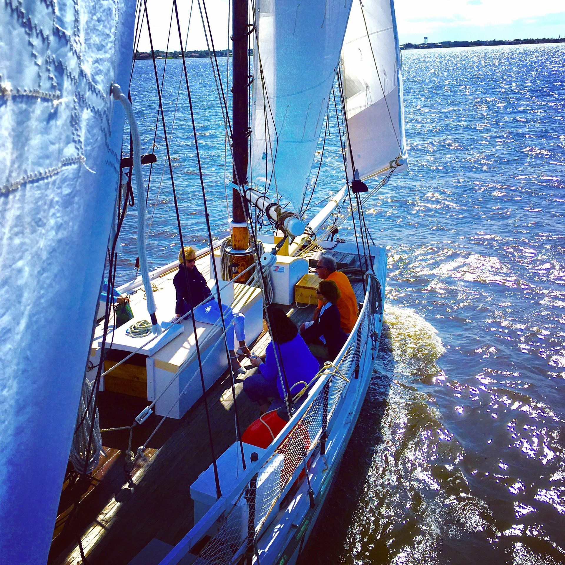 A group of people are on a sailboat in the water