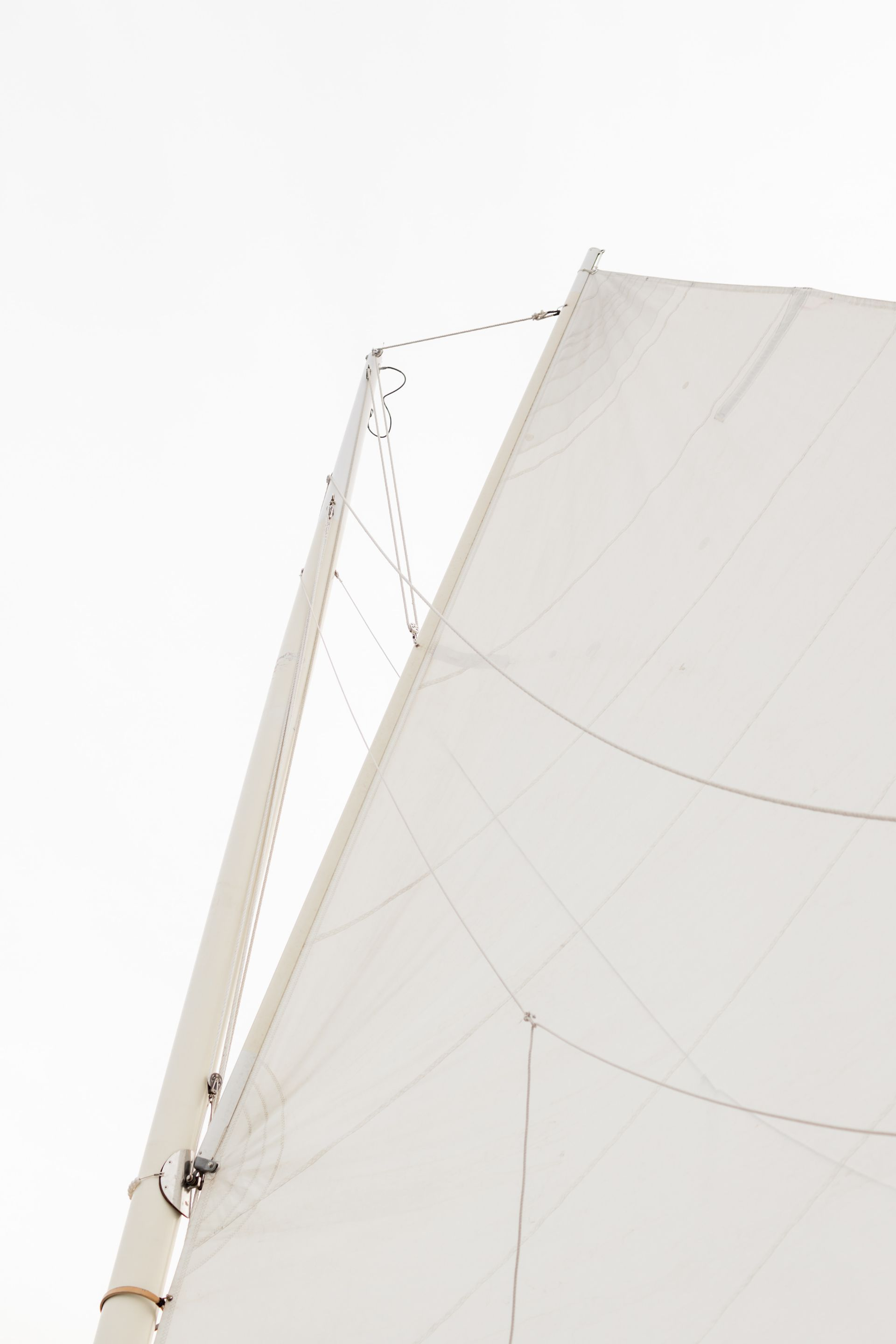 A close up of a sail on a sailboat against a white background.
