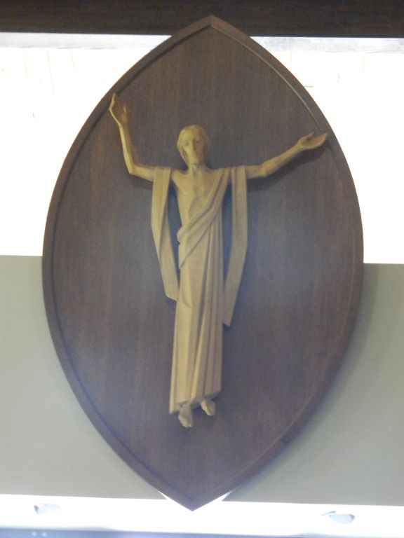 Wooden sculpture of Jesus with outstretched arms.
