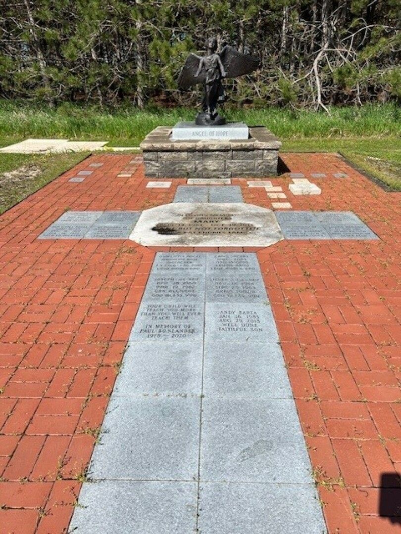 A bronze angel statue stands on a stone pedestal labeled Angel of Hope.