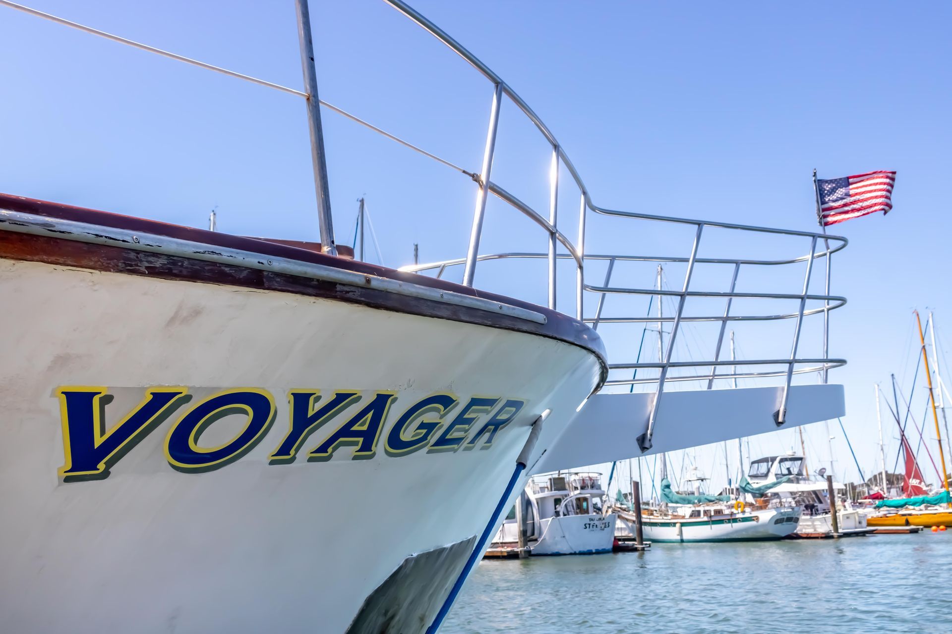 Person on a boat releasing a fishing net into the water, held with a basket and gloved hand.