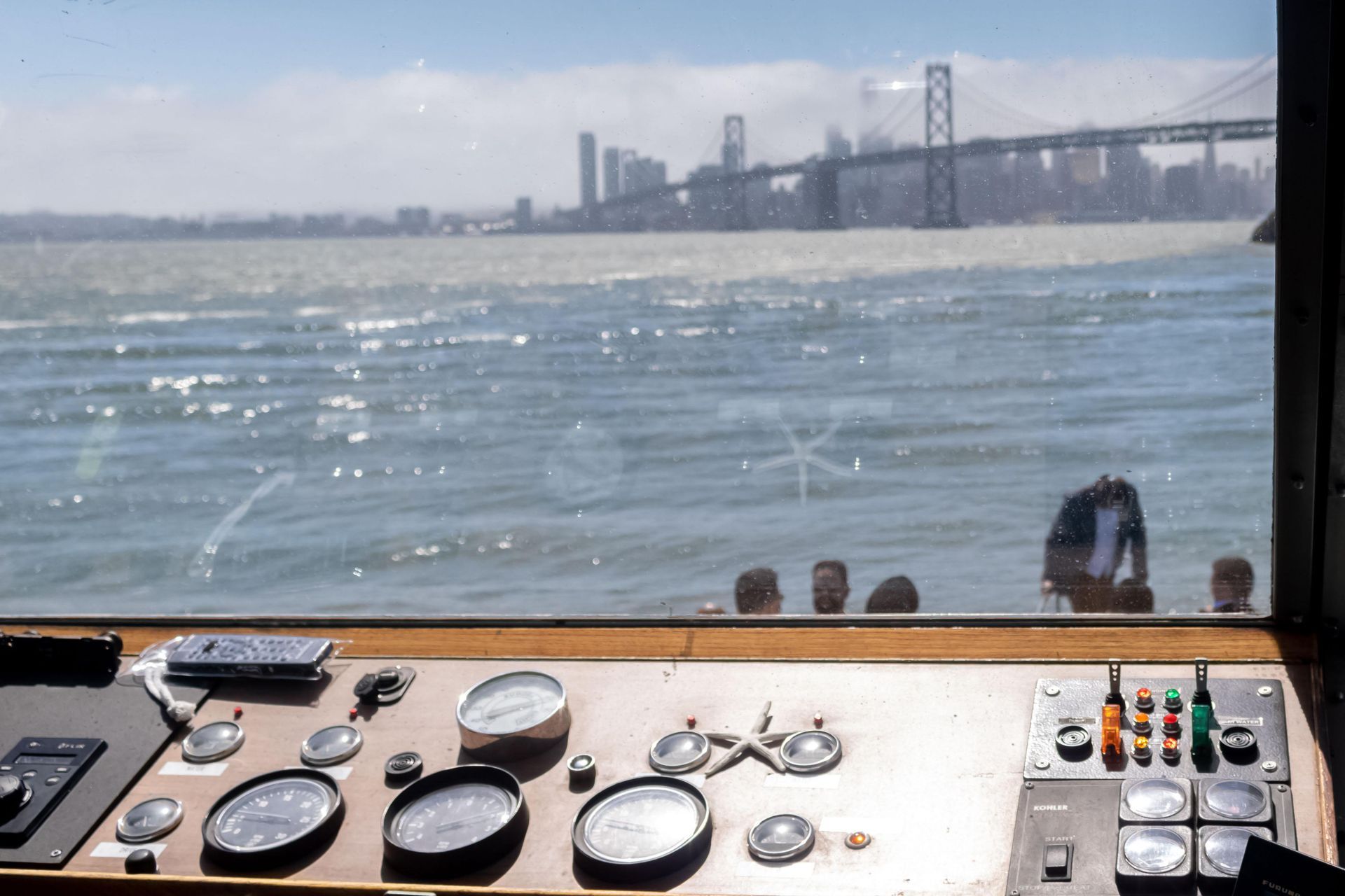 People on a boat toast with drinks against a sunset.