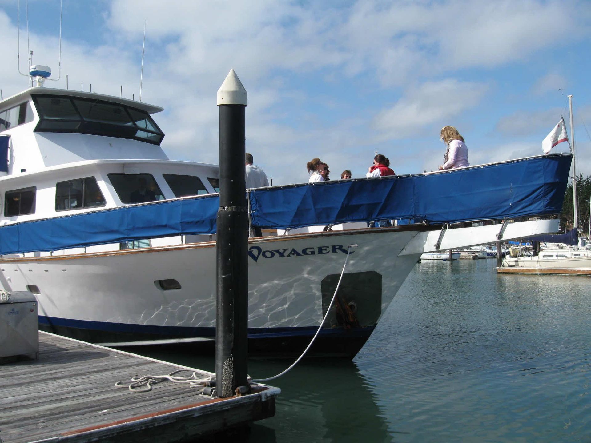 People on a boat toast with drinks against a sunset.
