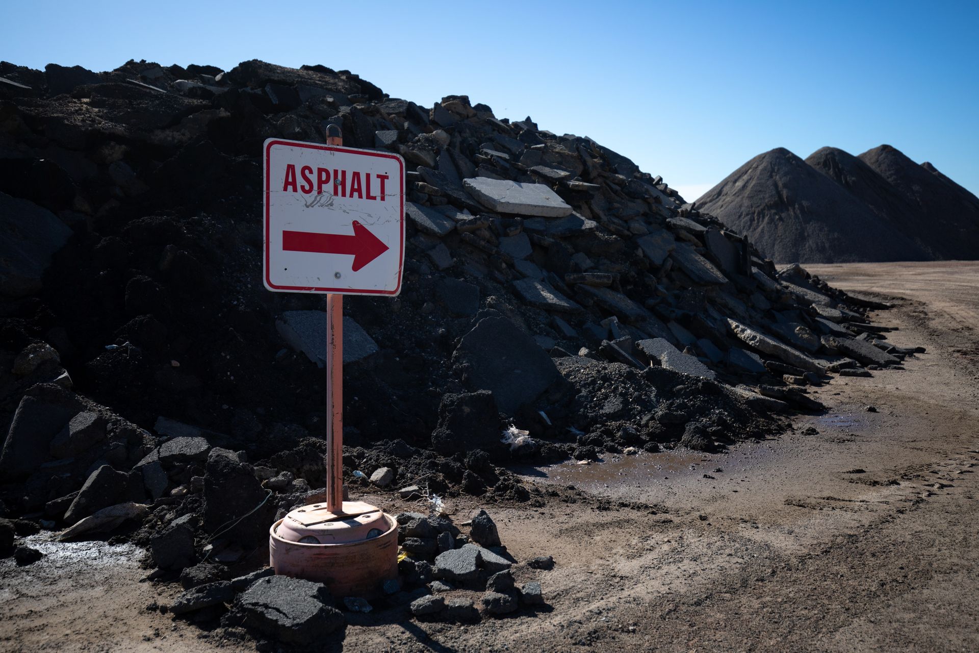 A sign that says asphalt with an arrow pointing to the right