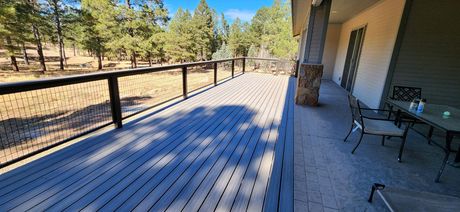 A wooden deck with a fire pit and chairs