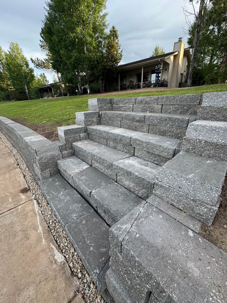 A brick wall with stairs leading up to it in a park.