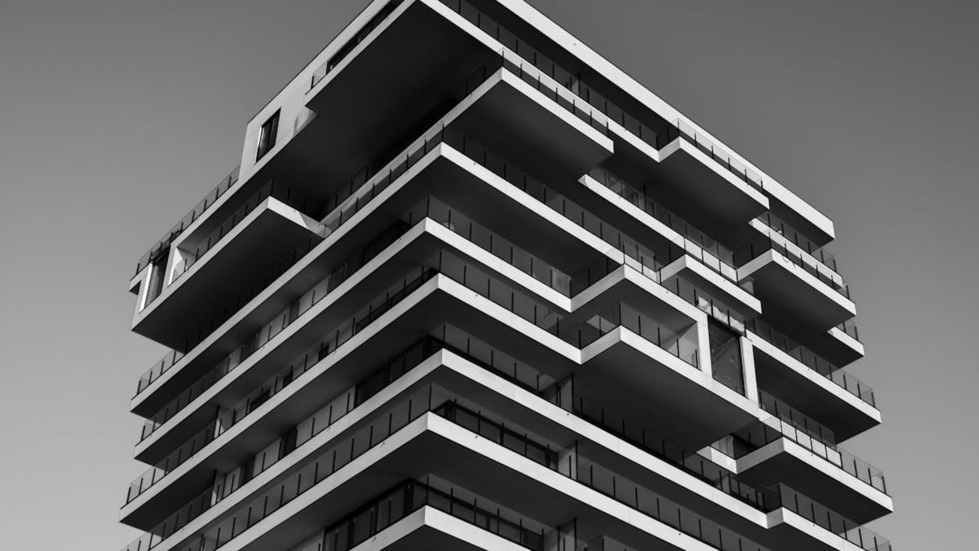 Una fotografía en blanco y negro de un edificio alto con muchos balcones.