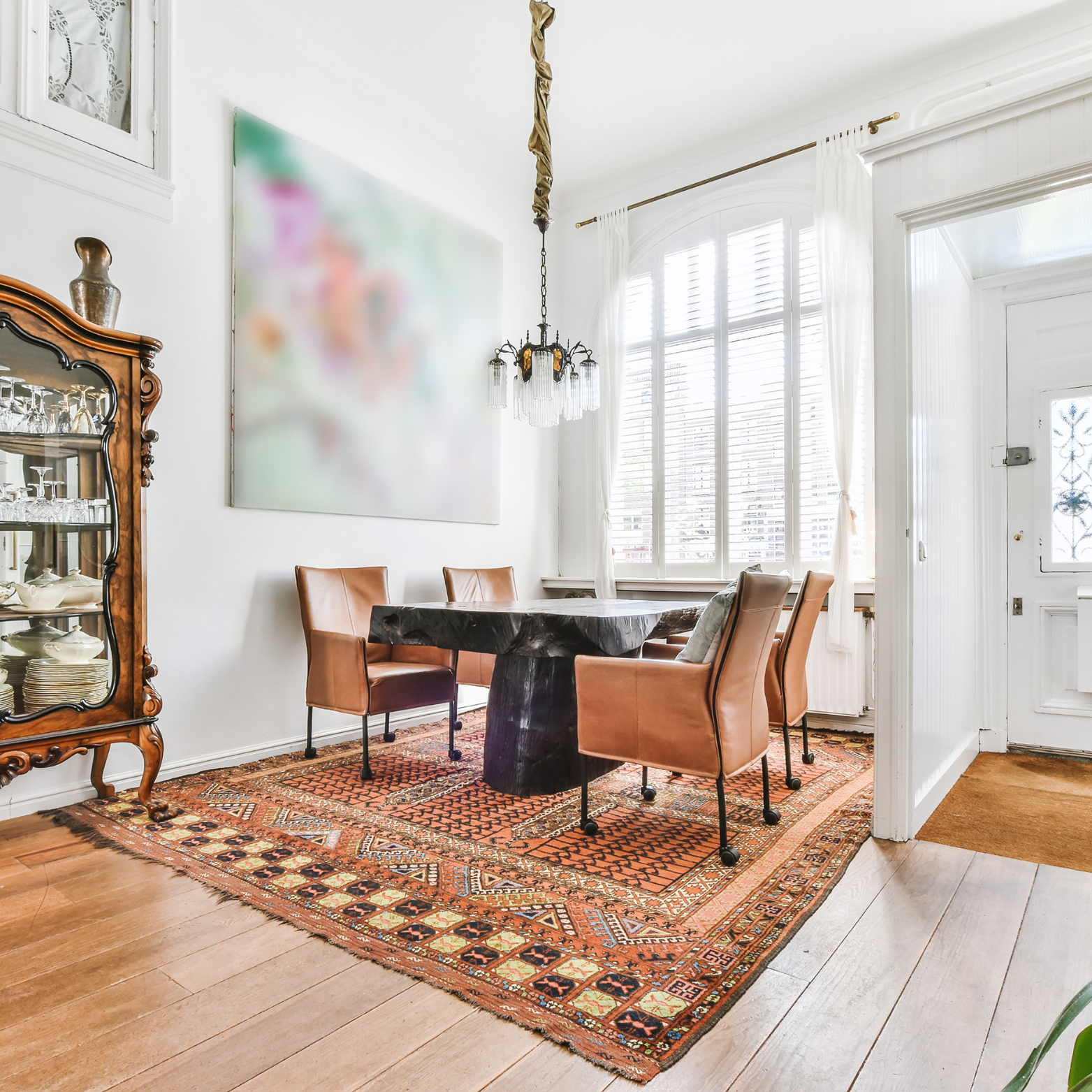 A dining room with a table and chairs and a rug