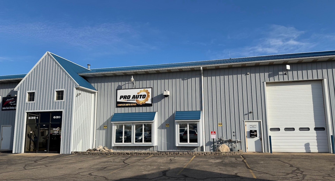 A gray industrial building with a blue roof, featuring a