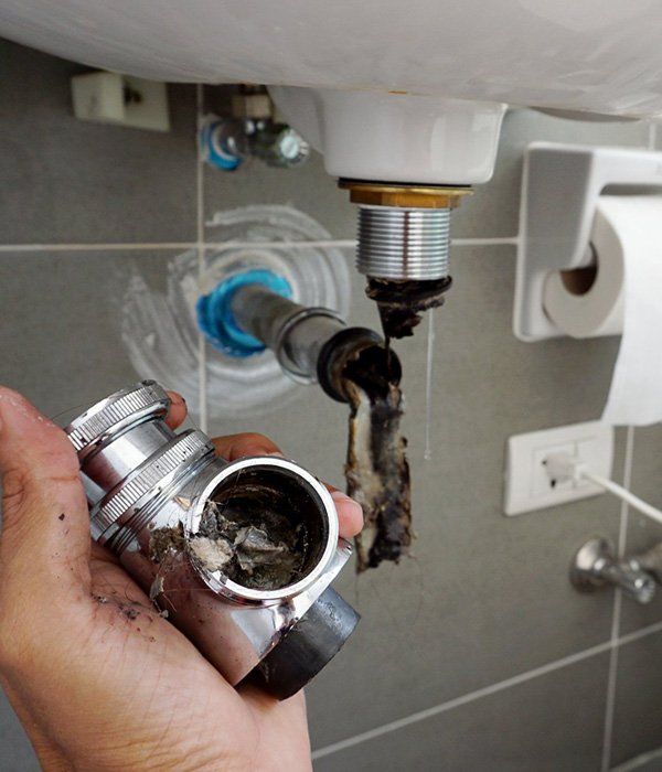 A Plumber Fixing A Clogged Drain — Ian Stanley Plumbing in Bundaberg QLD