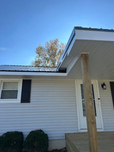 A white house with a porch and a blue sky in the background.