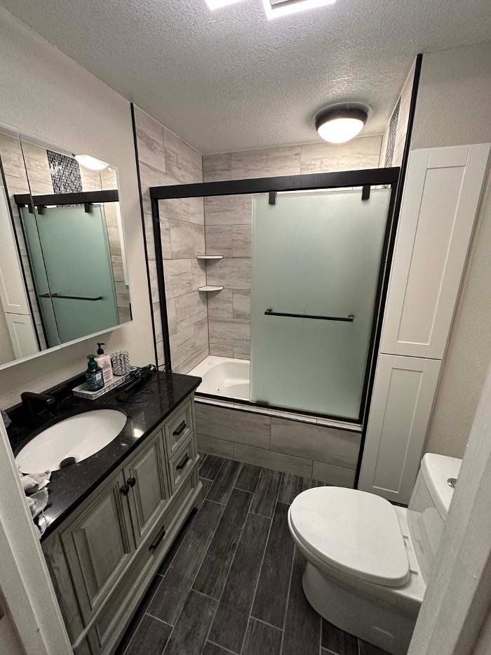A bathroom with a toilet , sink , and shower.