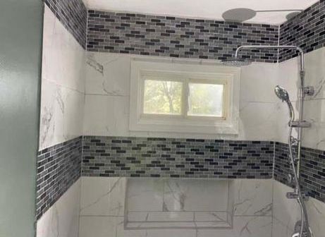 A bathroom with a shower head and a window.