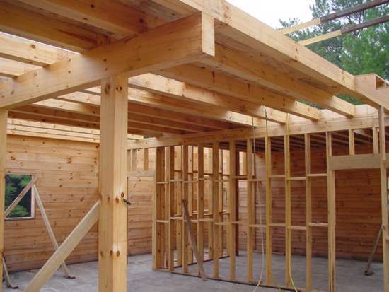 Wooden structure of a building under construction, showing framing, beams, and support posts.