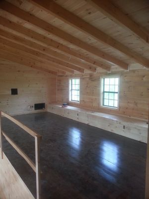 Interior loft with wooden beams, walls, and dark flooring. 