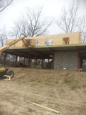 Construction site: a building with a wood roof and steel supports. 