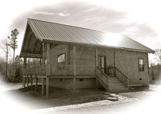Wooden cabin with a porch and metal roof.