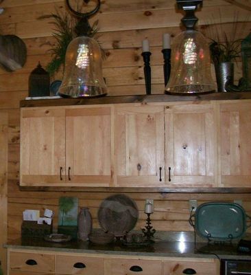 Wooden kitchen cabinets with open shelving and decorative items.