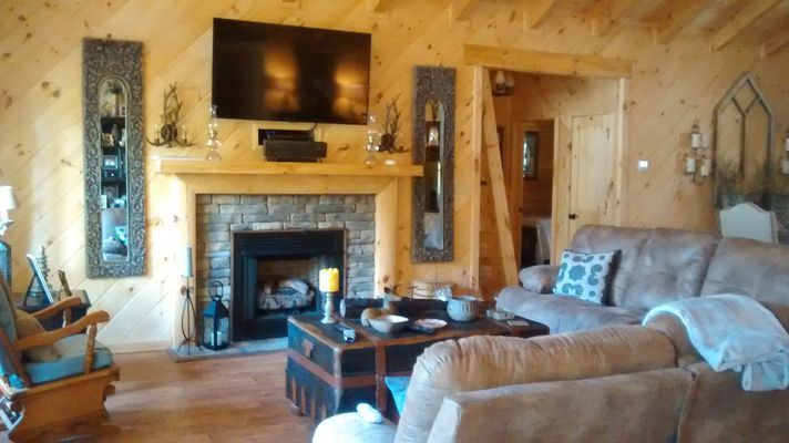 Living room with fireplace, TV, and brown furniture. 