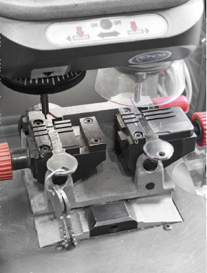 A close up of a machine that is cutting keys